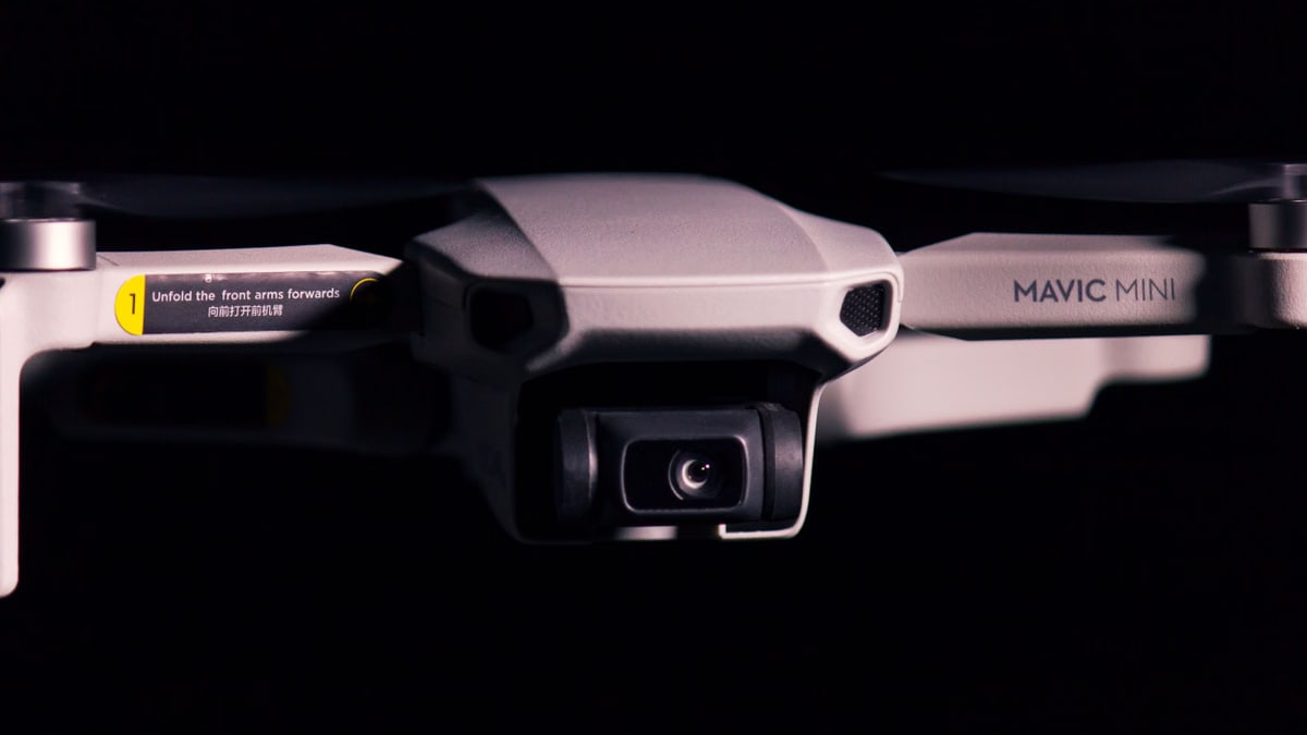 Detailed shot of a Mavic Mini drone showcasing its camera and design against a black background.